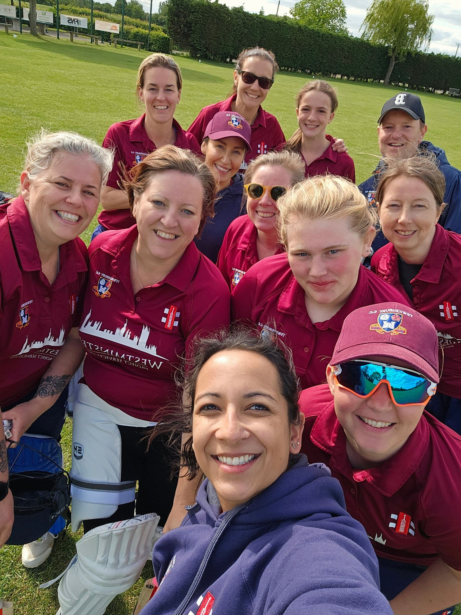 The Tewkesbury women's team crowded into a smiling selfie on the outfield