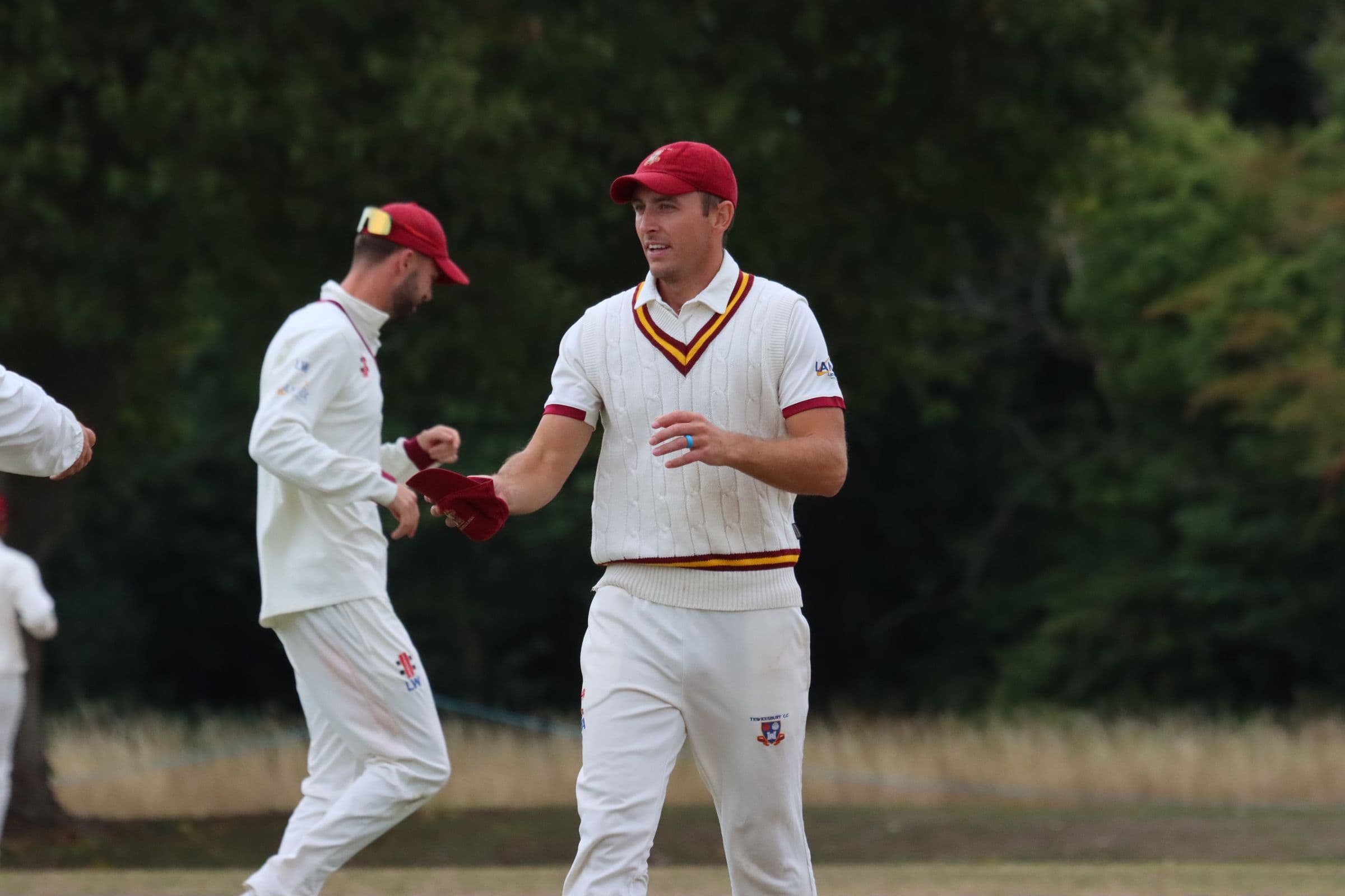 A Tewkesbury fielder handing back a cap between overs