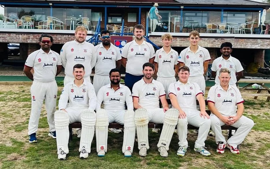 A Tewkesbury men's XI in whites, lined up in front of the pavilion